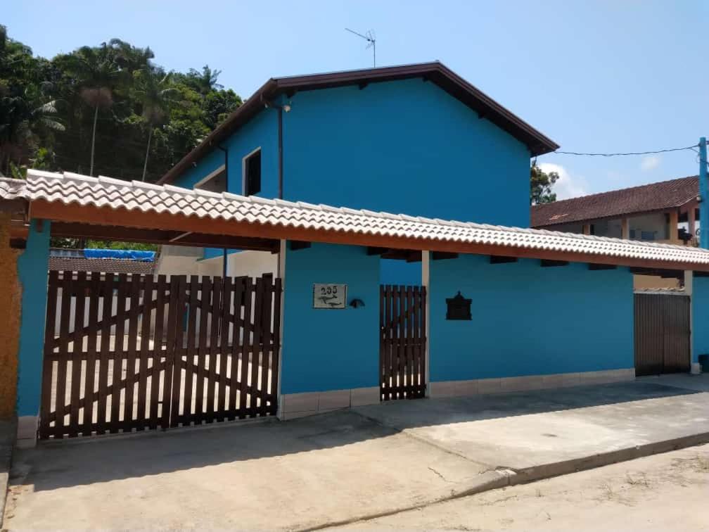 une maison bleue avec une porte en face dans l'établissement Recanto Jubarte (Massaguaçu Caraguatatuba - SP), à Caraguatatuba