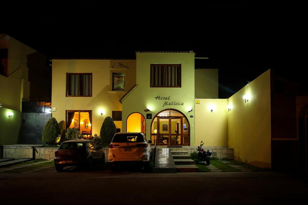 a car parked in front of a building at night at Hotel Meliana in Arequipa