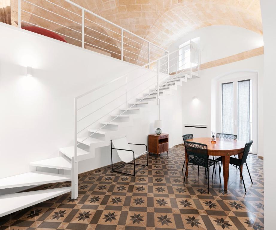 a dining room with a table and a staircase at MOH - Casa Vacanze in Grottaglie