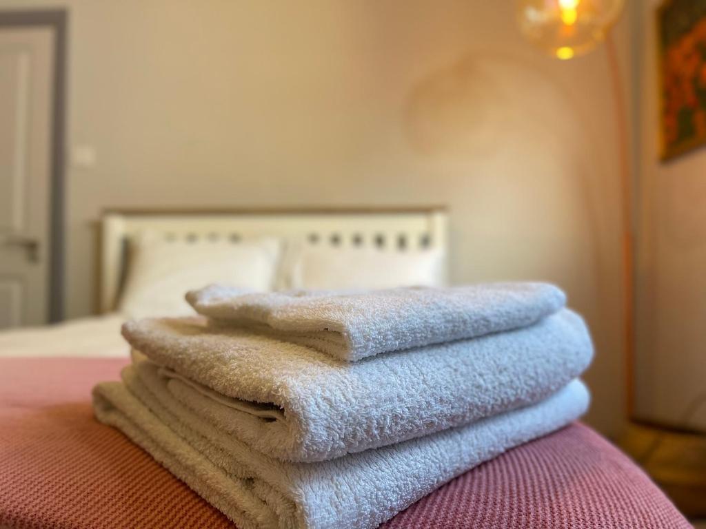 a pile of towels sitting on top of a bed at Spacious Double Room with Private Bathroom in Streatham Common, Southwest London in Streatham Vale