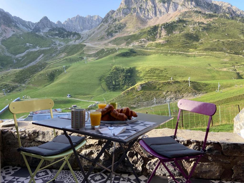 une table avec une assiette de nourriture et deux chaises dans l'établissement Studio 4 pers plein pied résidence Bero Bisto, face aux pistes, à Bagnères-de-Bigorre