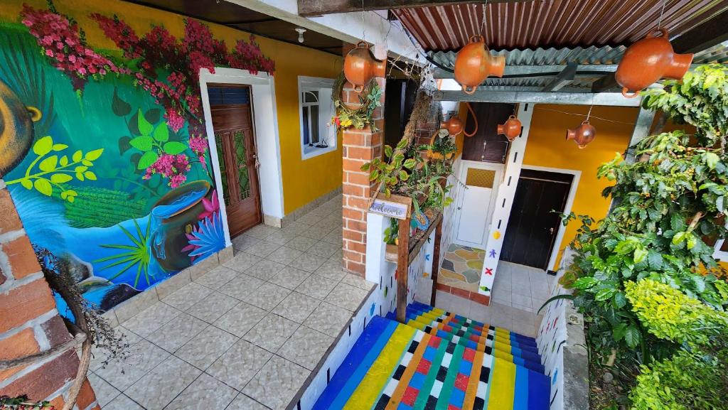 une maison avec un mur peint coloré et une terrasse couverte dans l'établissement Posada Woochooch, à San Juan La Laguna