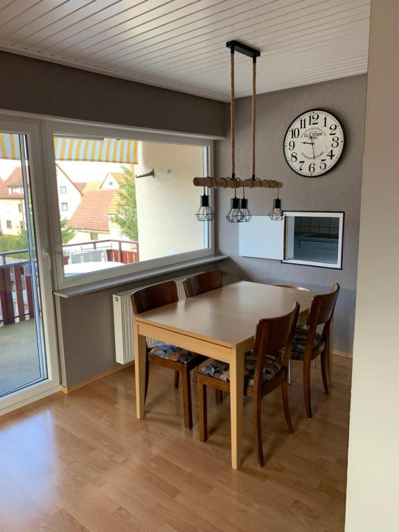 a dining room with a table and chairs and a clock at FeWo Saier in Althengstett