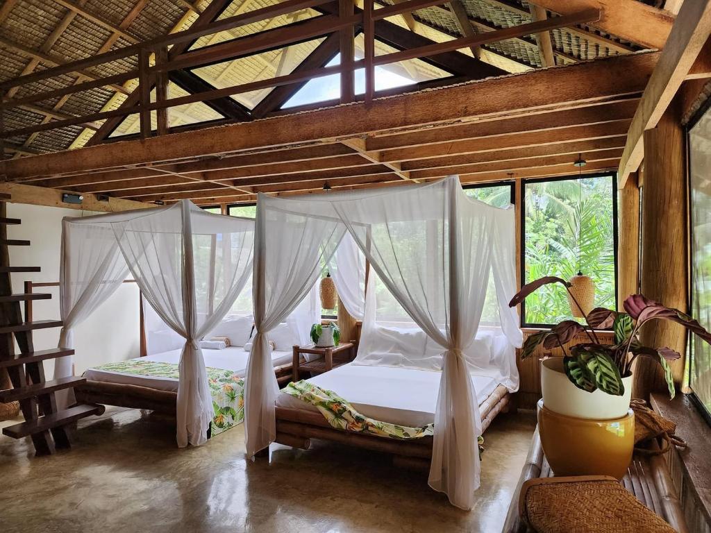 dwa łóżka w pokoju z oknami w obiekcie Nay Morena Villa 