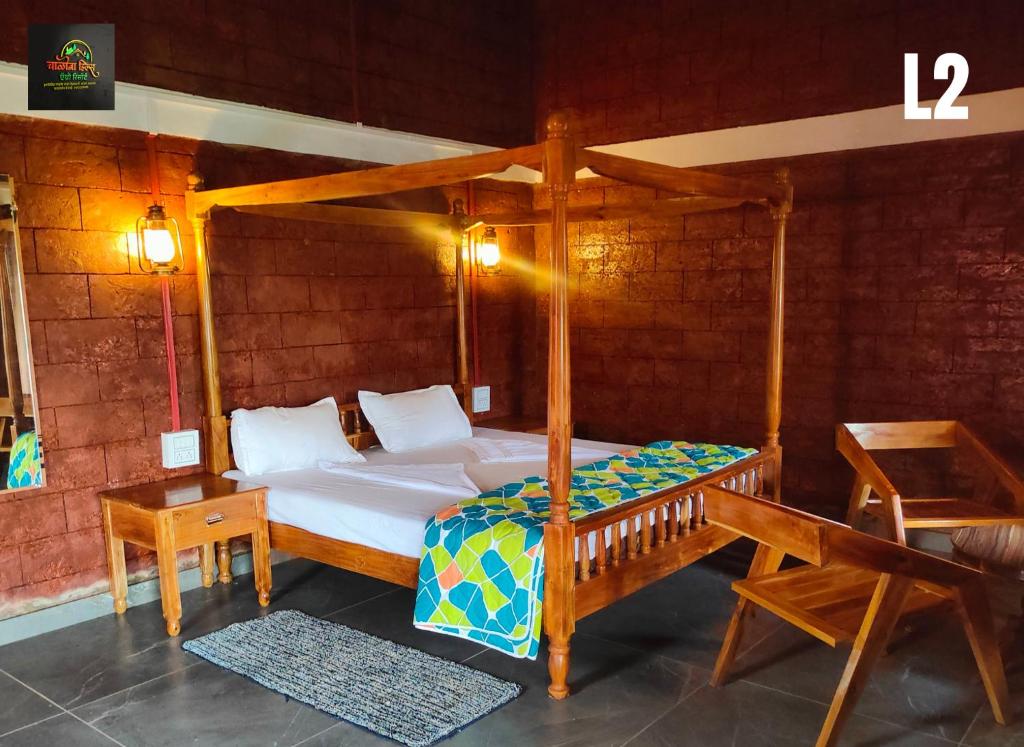 a bedroom with a canopy bed and a bench at Chalobahills Farmstay Resort in Ajra