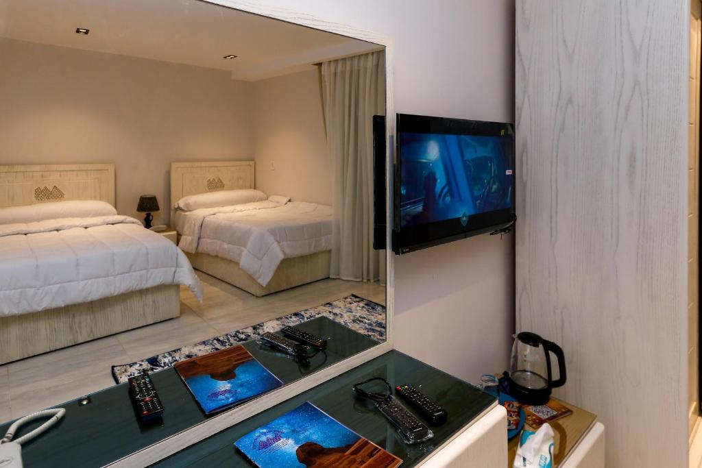 Habitación de hotel con 2 camas y TV en Pyramids Land Hotel, en El Cairo