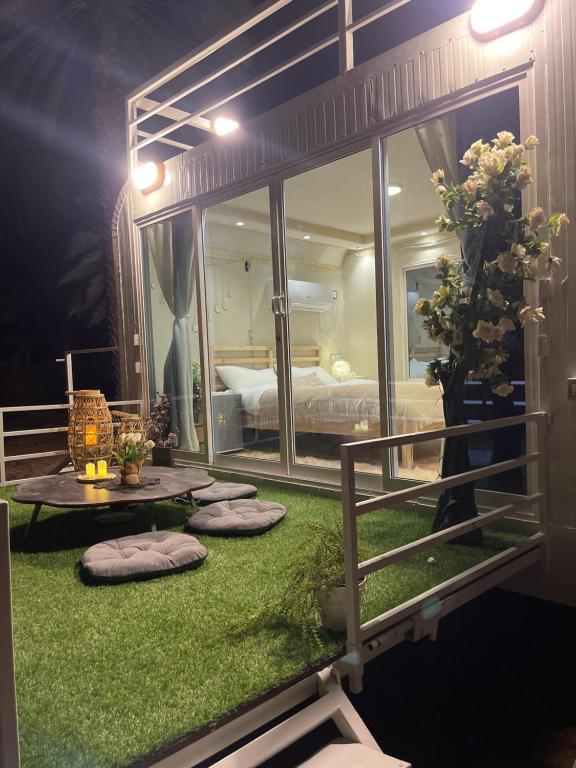 Habitación con cama y césped verde en Five caravan, en Al Ula