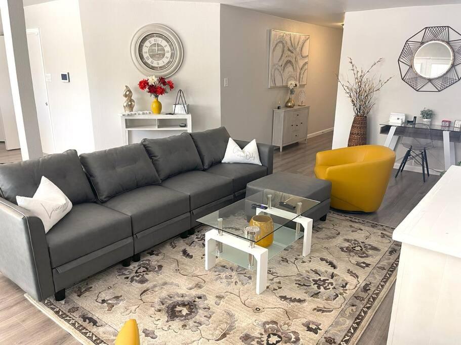uma sala de estar com um sofá preto e uma cadeira amarela em The Texas Rose em San Antonio
