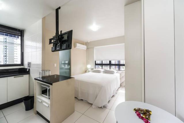 a hotel room with a bed and a tv and a bathroom at Classic Golden Point - Boa Viagem in Recife