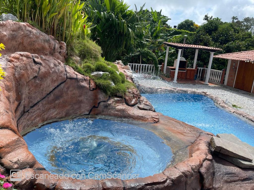 una gran piscina con una gran roca alrededor en La mejor opción para tu descanso y recreación., en Mariquita