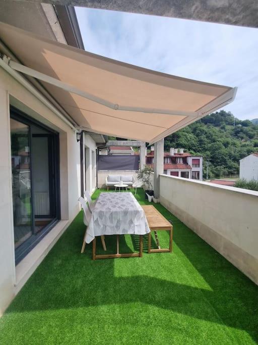 a patio with a table and chairs on a balcony at La Casina Del Alce in Aller