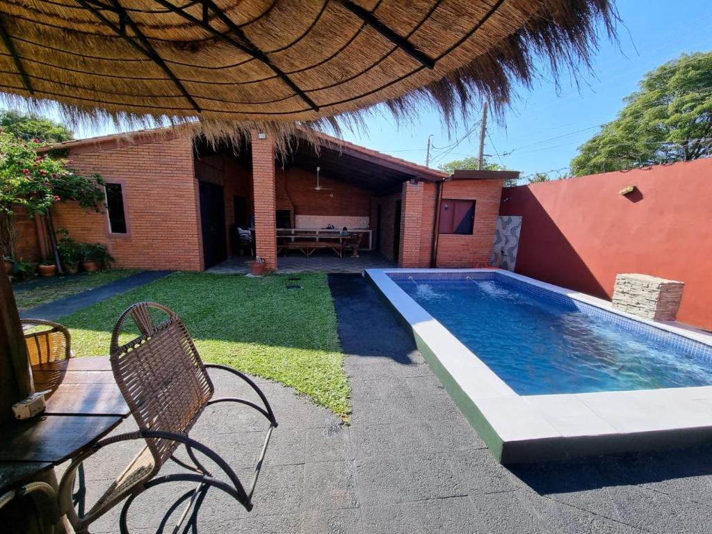 a backyard with a swimming pool and a house at Hospedaje Confortable en Luque in Luque