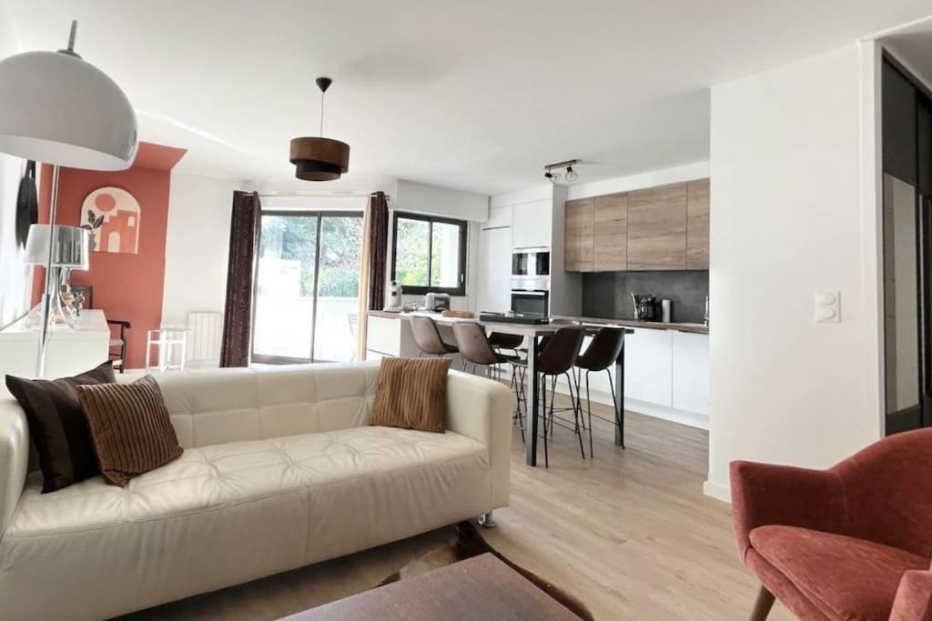 a living room with a couch and a kitchen at Appartement 2 chambres centre in Pessac