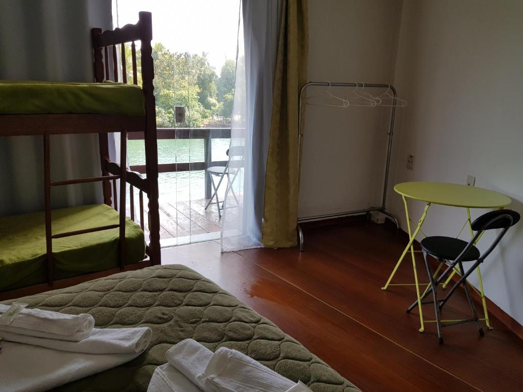 um quarto com uma cama, uma mesa e uma janela em Pousada Miami no Rio de Janeiro