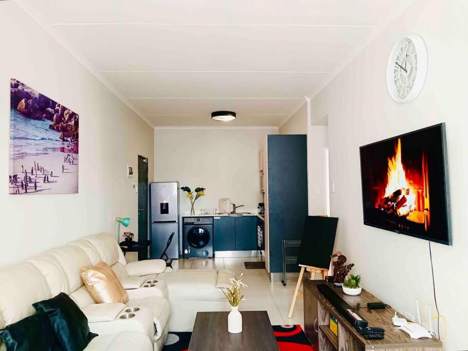 a living room with a white couch and a fireplace at Bounce Modern Home of Comfort 2 in Midrand