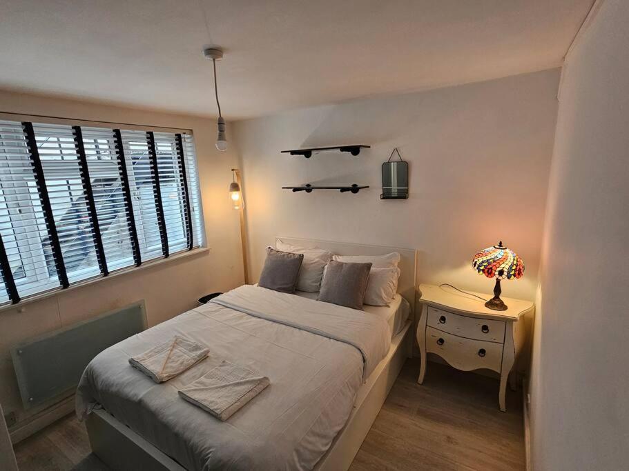a bedroom with a large bed and a night stand at Peaceful and Elegant in London