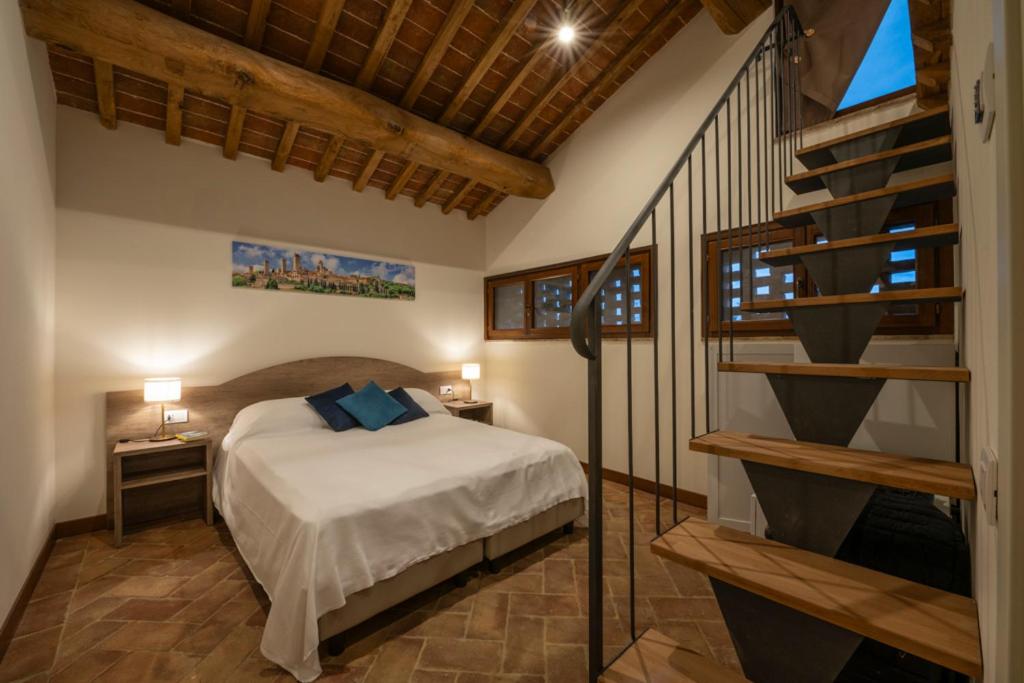 um quarto com uma cama e uma escada em espiral em Podere Valserena em Monteroni dʼArbia