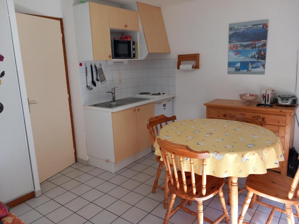 une cuisine avec une table, des chaises et un évier dans l'établissement Studio pour 3 pers. à Châtel avec balcon, parking, près navettes et centre. Exposition Sud/Ouest. - FR-1-676-115, à Châtel