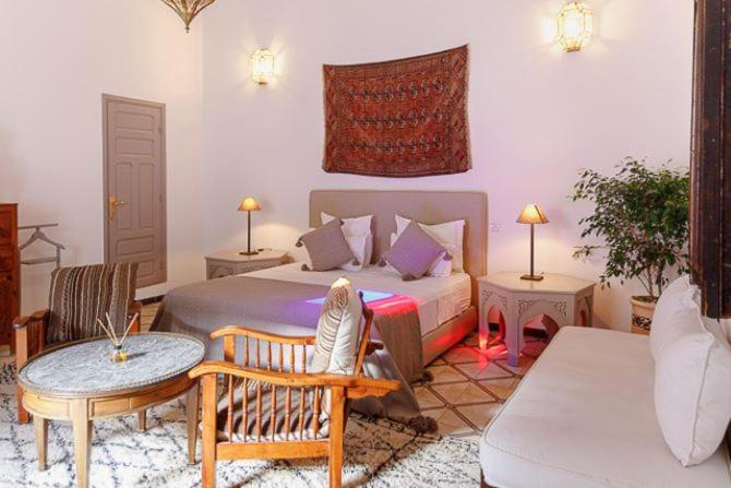 a bedroom with a bed and a table and a couch at Riad Zouhour in Marrakech