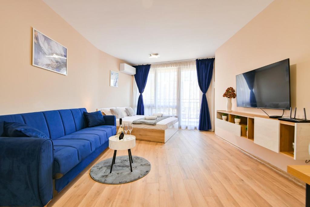 een woonkamer met een blauwe bank en een tv bij Armand de Azurro in Sofia