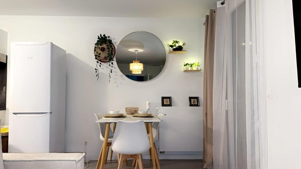 - une cuisine avec une petite table et un miroir dans l'établissement Ndianda, à Bordeaux