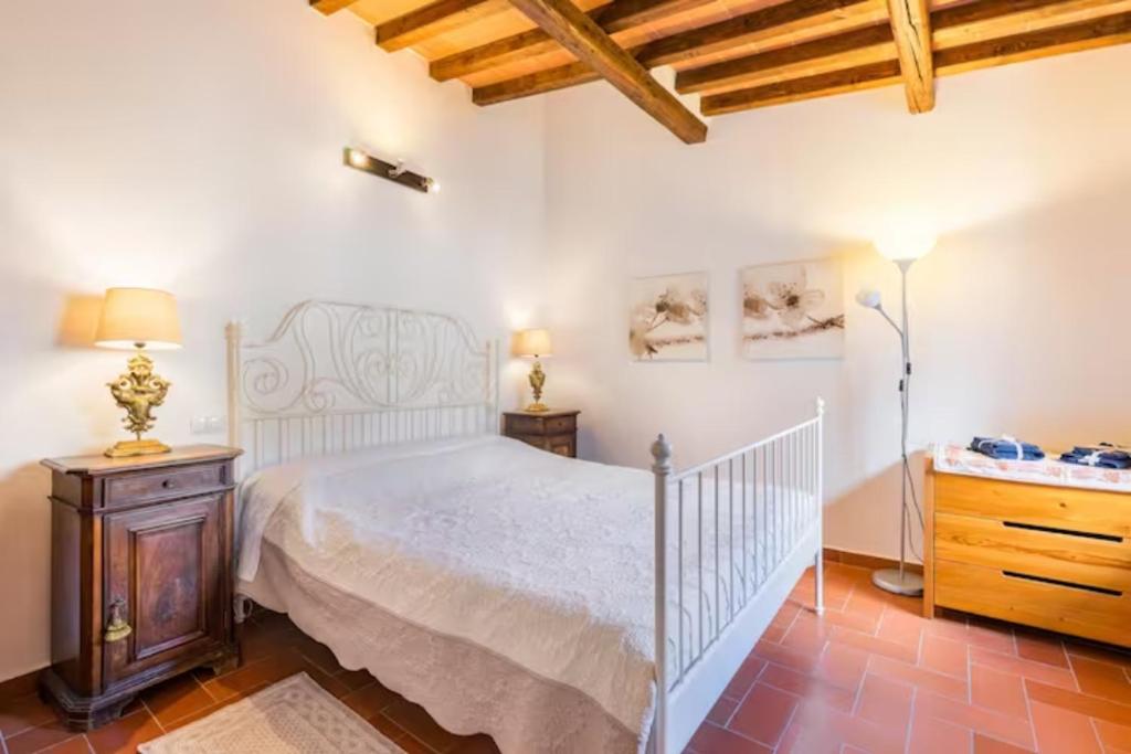 a bedroom with a white bed and a wooden dresser at DaLu Florence apartment Lucilla - private car park 15 minutes to the city center in Florence