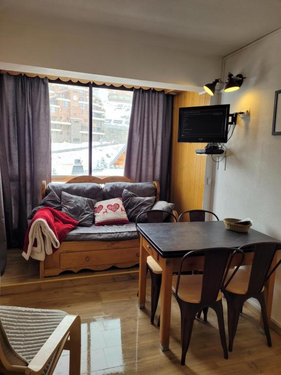 een woonkamer met een bank en een tafel bij Val Thorens, Centre Station, résidence Ski aux pieds, FREE WIFI, in Val Thorens