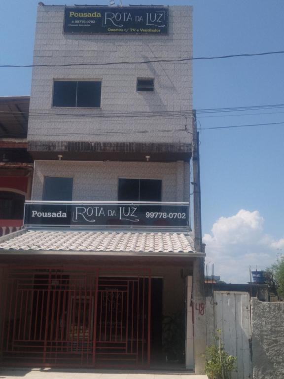 un bâtiment avec un panneau sur son côté dans l'établissement Pousada Rota da Luz, à Aparecida