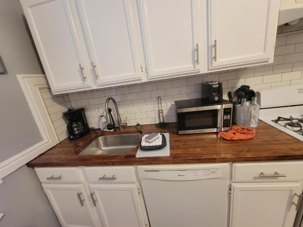 a kitchen counter with a sink and a microwave at Spacious One Bedroom Apartment in Soulard