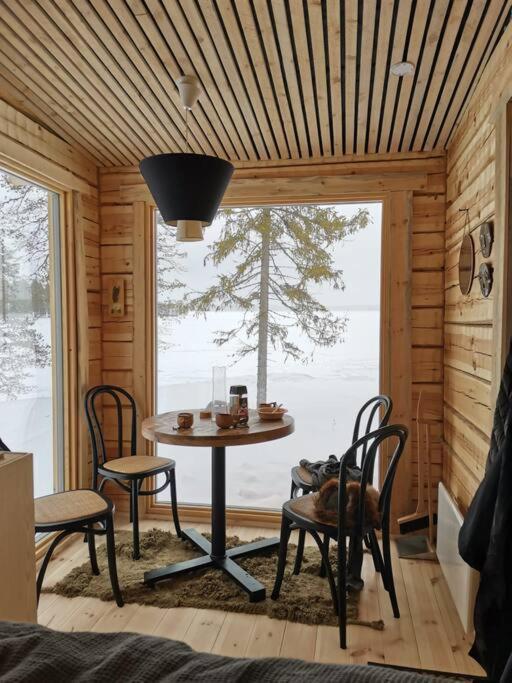 een kamer met een tafel en stoelen in een hut bij Wilderness Cabin Onnela in Rovaniemi