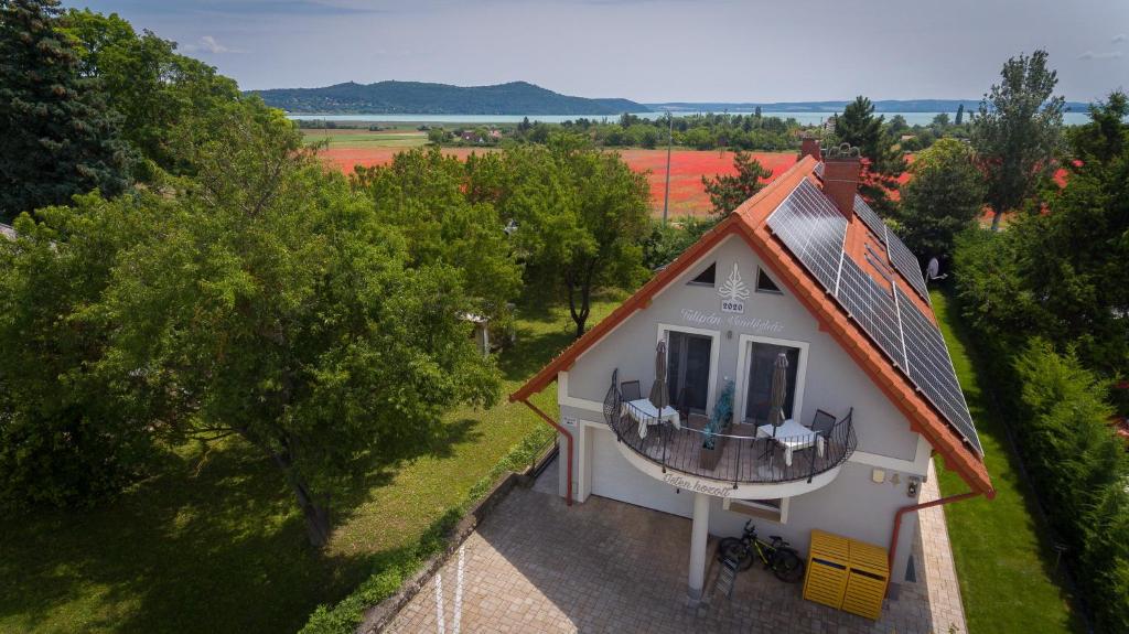een balkon met uitzicht op een wit huis bij Tulipán vendégház in Örvényes