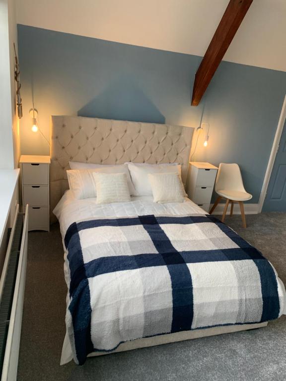 a bedroom with a bed with a blue and white blanket at The Vicarage in Sunderland