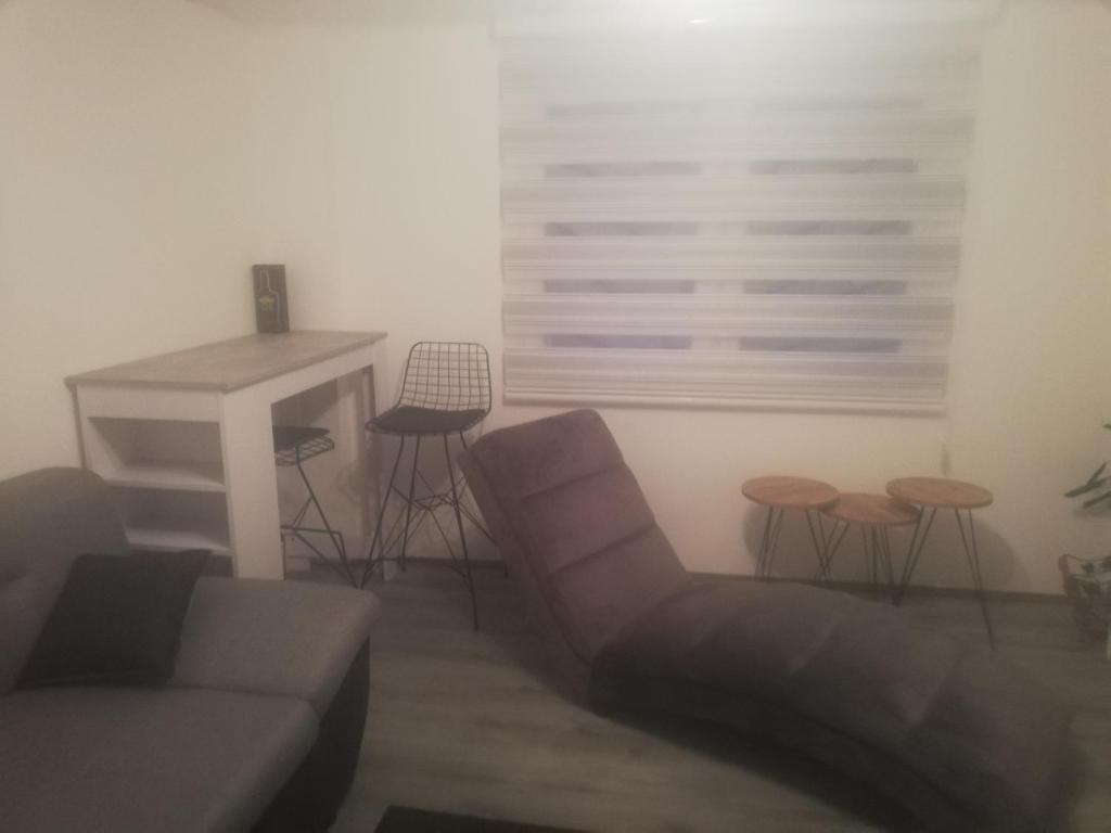 a living room with a couch and a table and stools at Apartman Ivana in Užice
