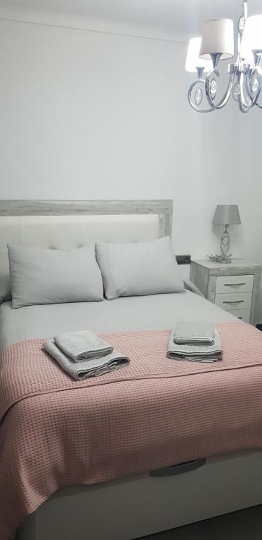 a bedroom with a bed with two towels on it at Apartamento ROSA in Valle de Abdalagís