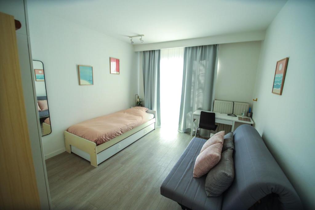 ein Wohnzimmer mit einem Sofa und einem Bett in der Unterkunft Privé kamer met chill room en gedeelde badkamer - rand Antwerpen - afrit E313 Wommelgem - vlakbij tramhalte lijn 9 en 24 in Antwerpen