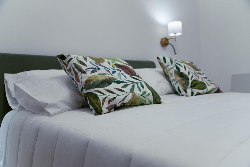 a white bed with two pillows on top of it at La Premiere Suite - Teatro Massimo Palermo in Palermo