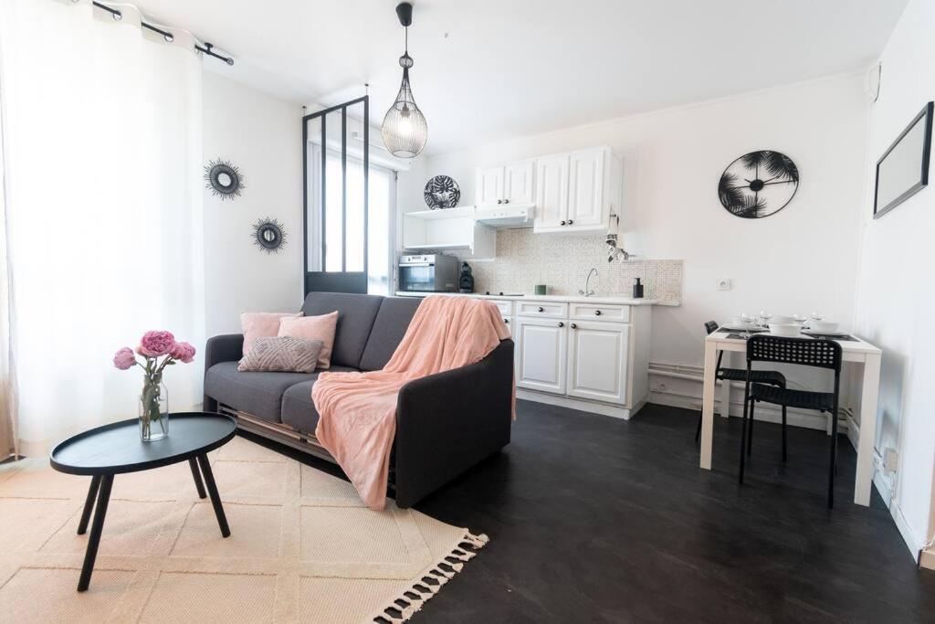 een woonkamer met een bank en een tafel en een keuken bij Le charmant Yin-Yang studio proche de Paris in Montrouge