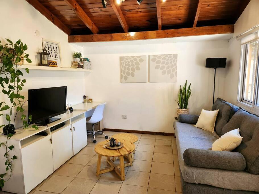 ein Wohnzimmer mit einem Sofa und einem Tisch in der Unterkunft Casa 2 ambientes en Tesei, Hurlingham in Morón