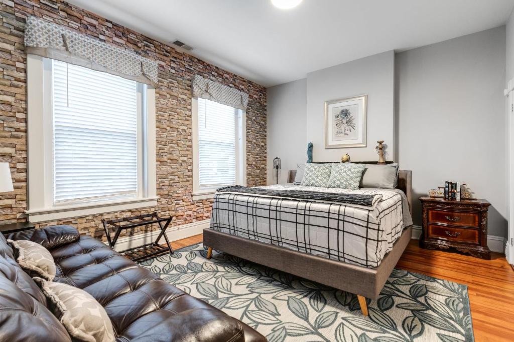 a bedroom with a bed and a brick wall at E2 Centrally located in Carytown fully fenced in Richmond