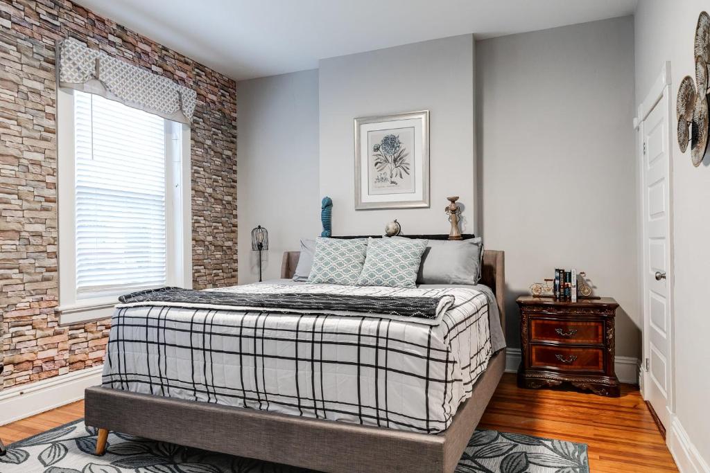 a bedroom with a bed and a brick wall at Centrally located in Carytown fully fenced in Richmond