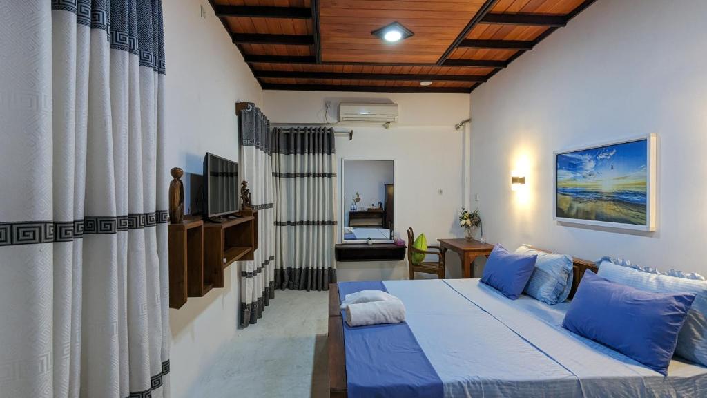 a bedroom with a bed with blue pillows at Jennifer's Villa in Negombo