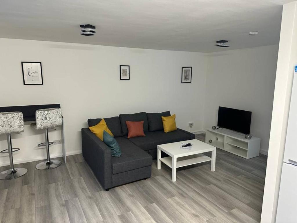 a living room with a couch and a tv at Stylish Apartment At Carlton Grove in London