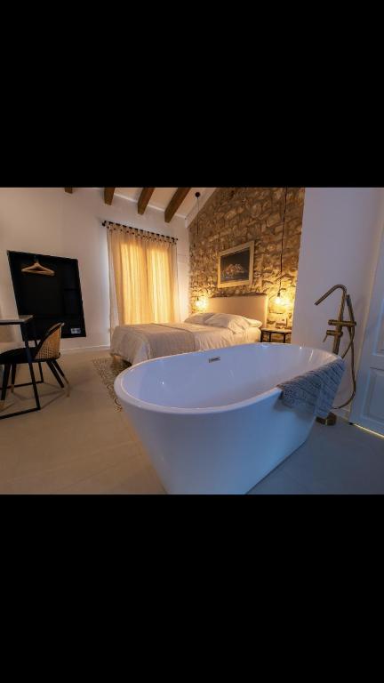 uma grande banheira branca num quarto com uma cama em MEDITERRÀNIA RURAL em Cabanes