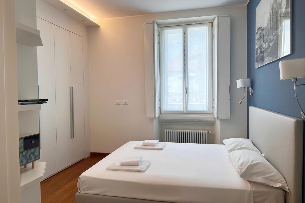ein weißes Bett in einem Zimmer mit Fenster in der Unterkunft Spazio Stoppani - Liberty 28 in Mailand