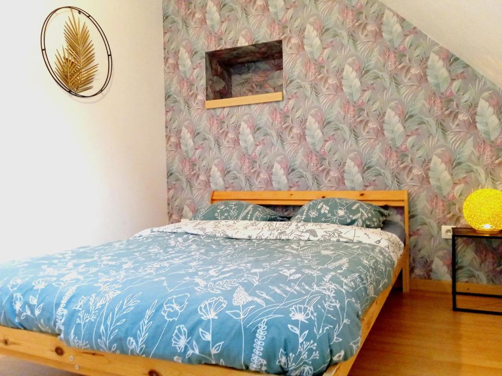 um quarto com uma cama com papel de parede floral em Élégante maison centre Romilly em Romilly-sur-Seine