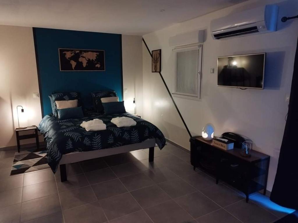 - une chambre avec un lit et un mur bleu dans l'établissement AJC Ô Spa, à Saulzoir