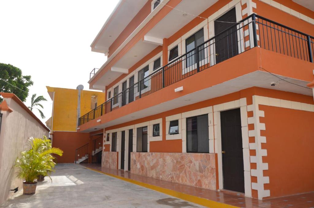Edificio naranja y blanco con balcón en Terracota Corner Rooms en Campeche