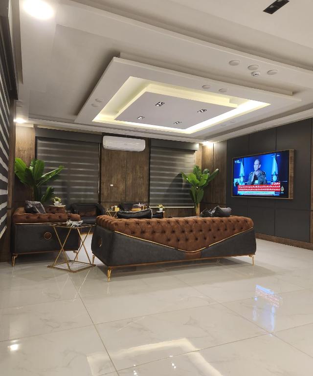un soggiorno con divano e TV a schermo piatto di رويال جروب للشقق الفندقية a Irbid