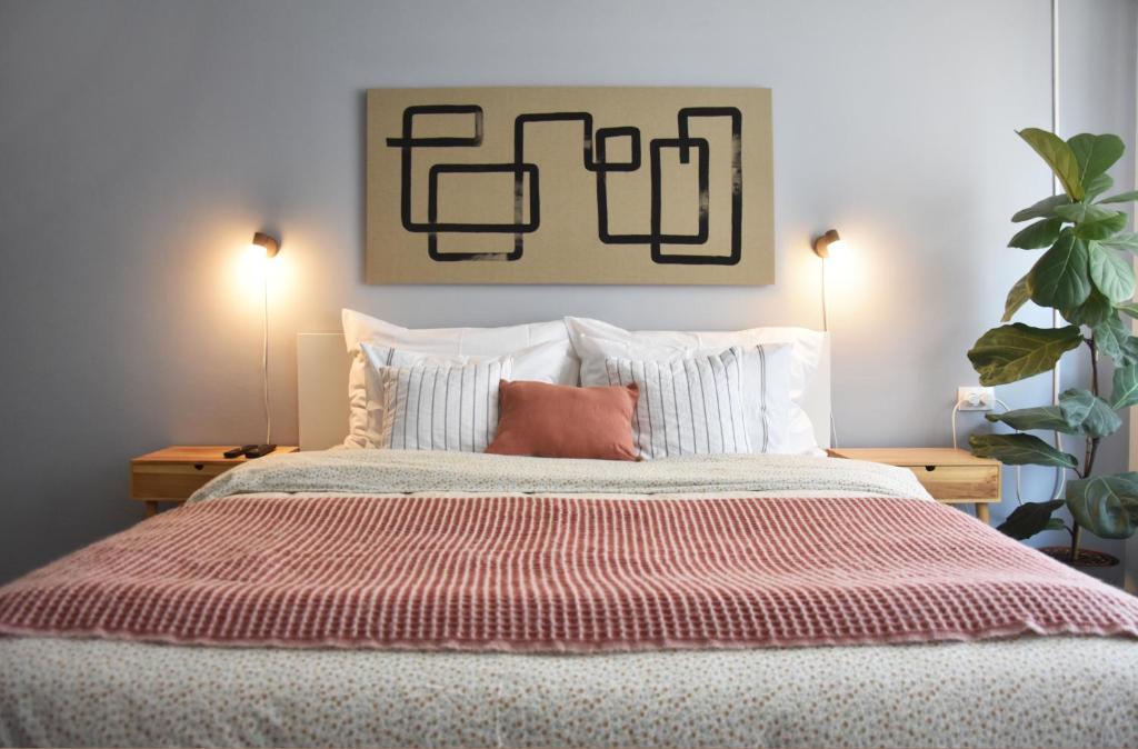 a bedroom with a large bed with pillows and two lamps at Pannonian sailor in Novi Sad