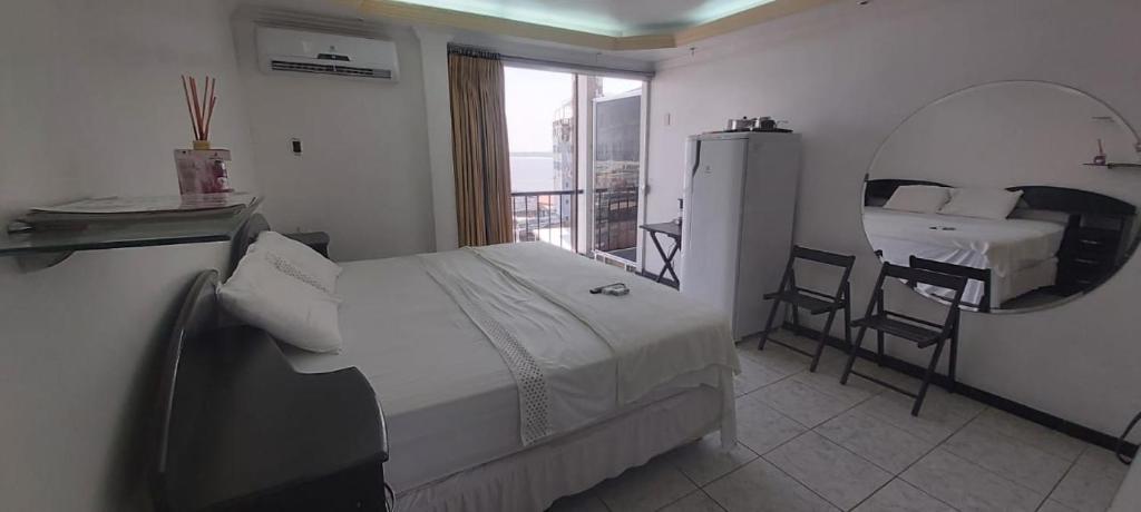 Schlafzimmer mit einem Bett, einem Spiegel und einem Tisch in der Unterkunft Riverfront Retreat Prime Location Apartment with Stunning Views of the RioNegro in Manaus